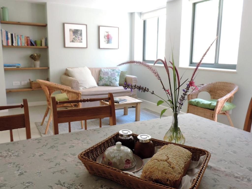 Midreshet Ben Gurion的住宿－沙漠玫瑰公寓，客厅配有一张桌子和一篮子食物