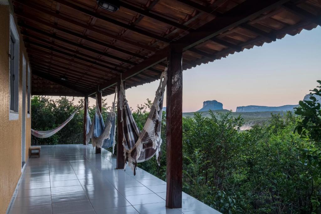 een veranda met hangmatten en uitzicht op de woestijn bij Pousada Bela Vista do Capão in Vale do Capao