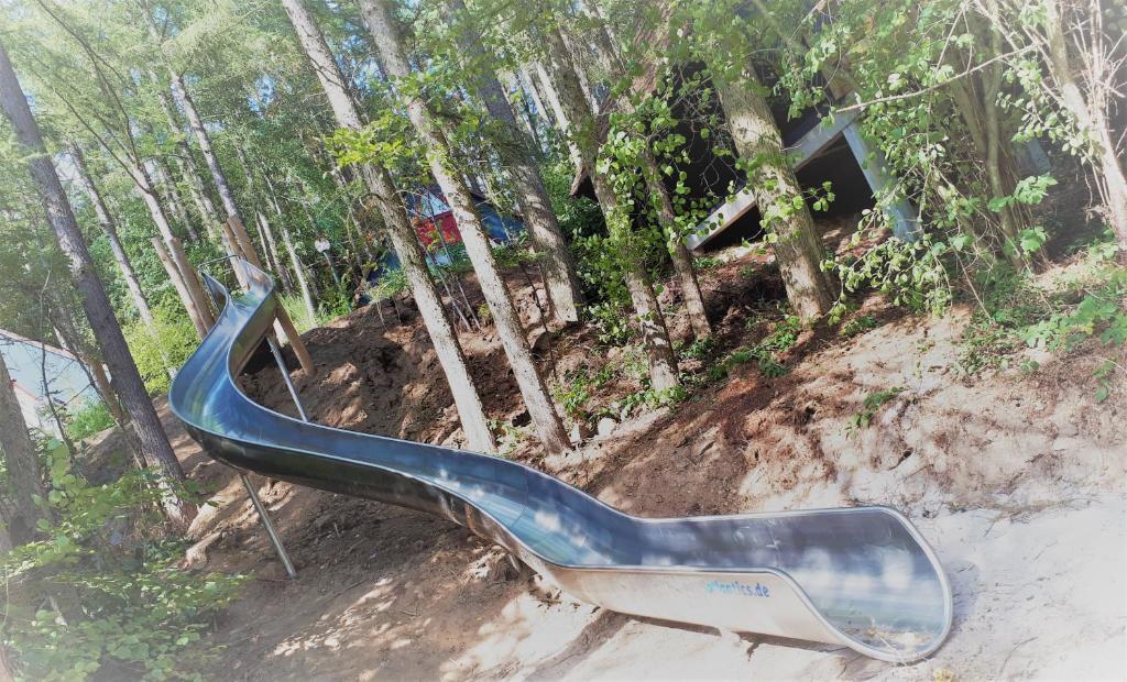 a bluepipe sitting in the dirt in front of trees at Domaine Long Pre in Stavelot