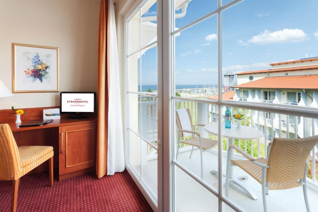 an office with a desk and a balcony with a view at Morada Strandhotel Ostseebad Kühlungsborn in Kühlungsborn