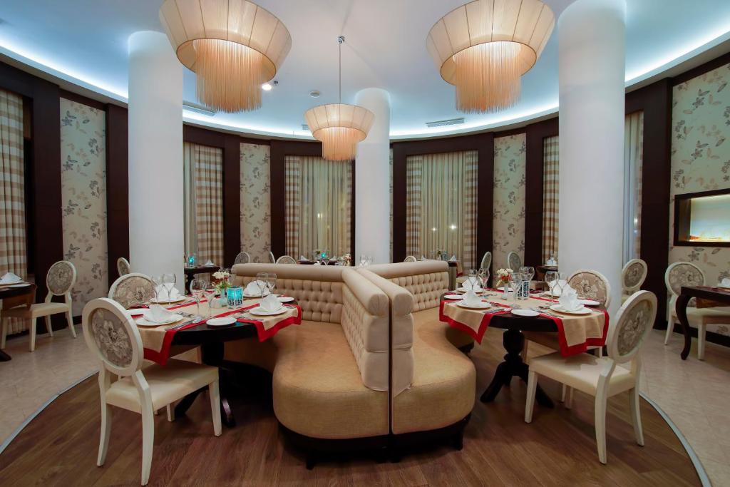 a dining room with tables and chairs and chandeliers at Limak Atlantis Deluxe Hotel Belek in Belek