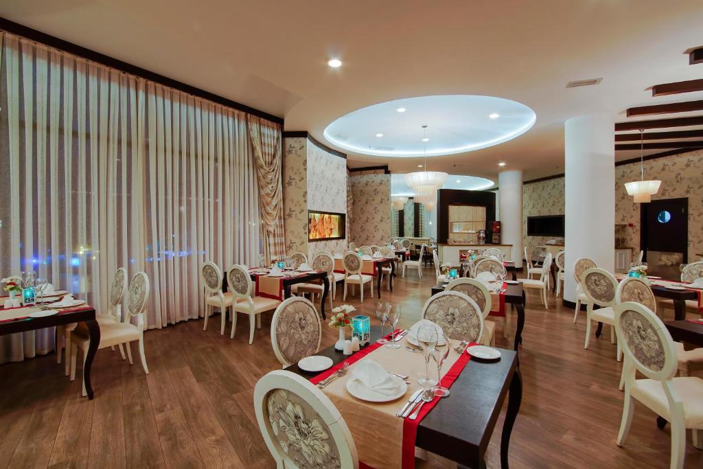 a dining room with tables and chairs and a large window at Limak Atlantis Deluxe Hotel Belek in Belek