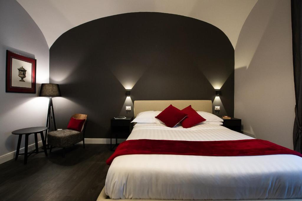- une chambre avec un grand lit et des oreillers rouges dans l'établissement Lungotevere Ripa, à Rome