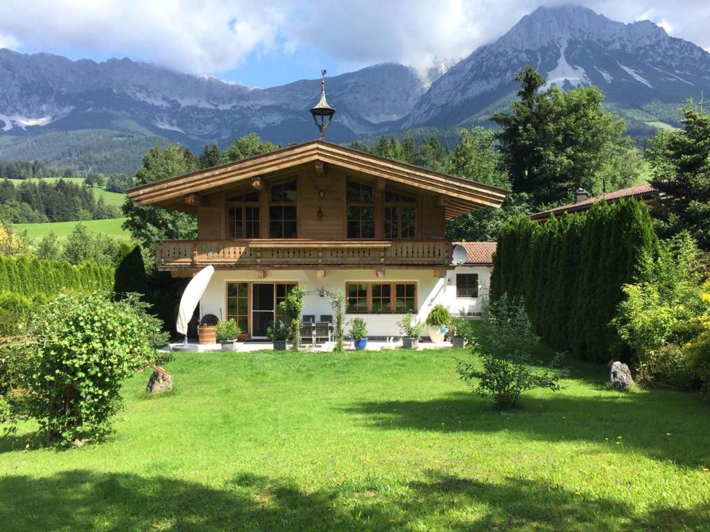 a house in a field with mountains in the background at Haus Bella in Ellmau