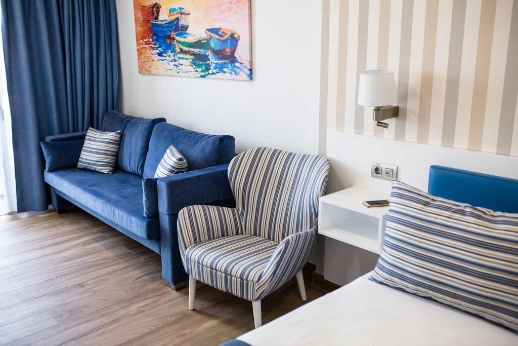 a living room with a blue couch and a chair at IG Nachosol Atlantic & Yaizasol by Servatur - Adults Only in Puerto Rico de Gran Canaria