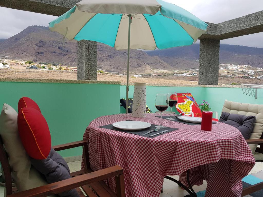 a table with an umbrella and glasses of wine at THE HAPPINESS PENTHOUSE Dream Holiday at 100m Beach! in Candelaria