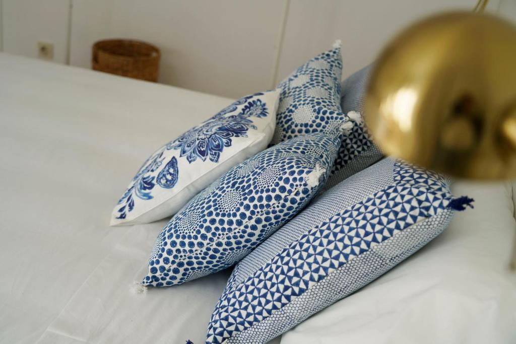a group of four blue and white pillows on a bed at Casa da Laurindinha in Ponte de Lima