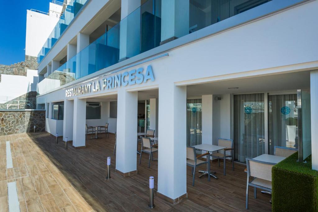 a building with tables and chairs outside of it at IG Nachosol Atlantic & Yaizasol by Servatur - Adults Only in Puerto Rico de Gran Canaria