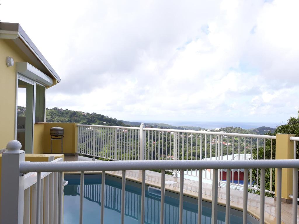 a balcony with a view of a swimming pool at Villa Lineddy in Quartier la Fleury Guiné