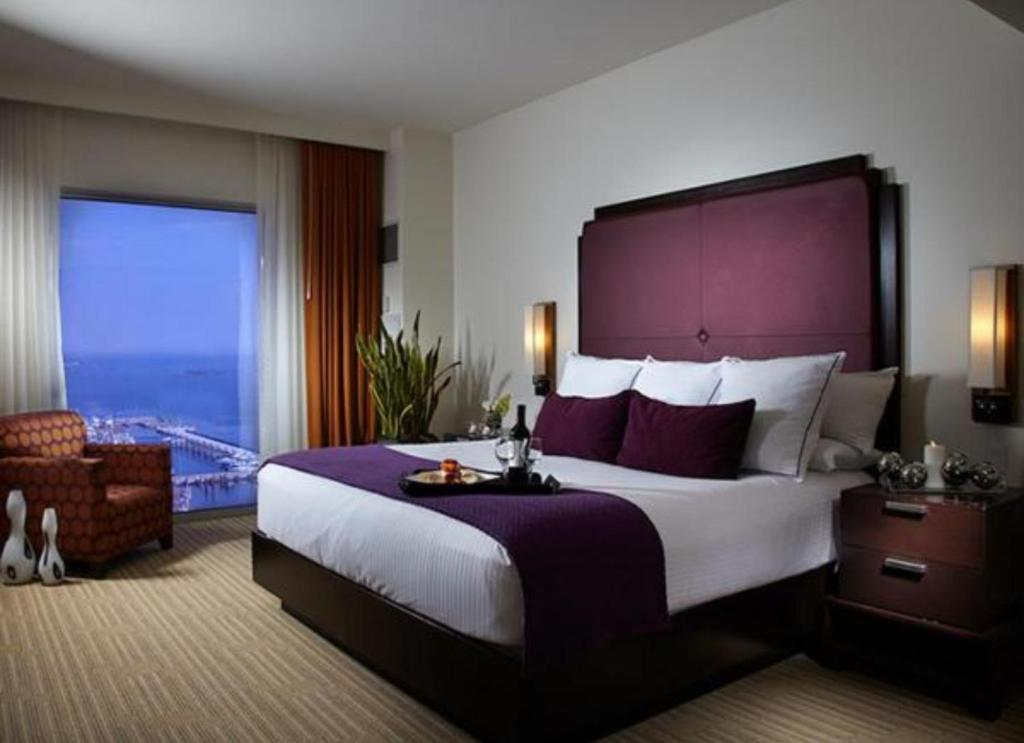 ein Hotelzimmer mit einem großen Bett und einem großen Fenster in der Unterkunft Hard Rock Hotel &amp; Casino Biloxi in Biloxi