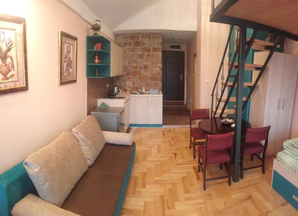 ein Wohnzimmer mit einem Sofa und einer Küche in der Unterkunft Bolonja in Užice