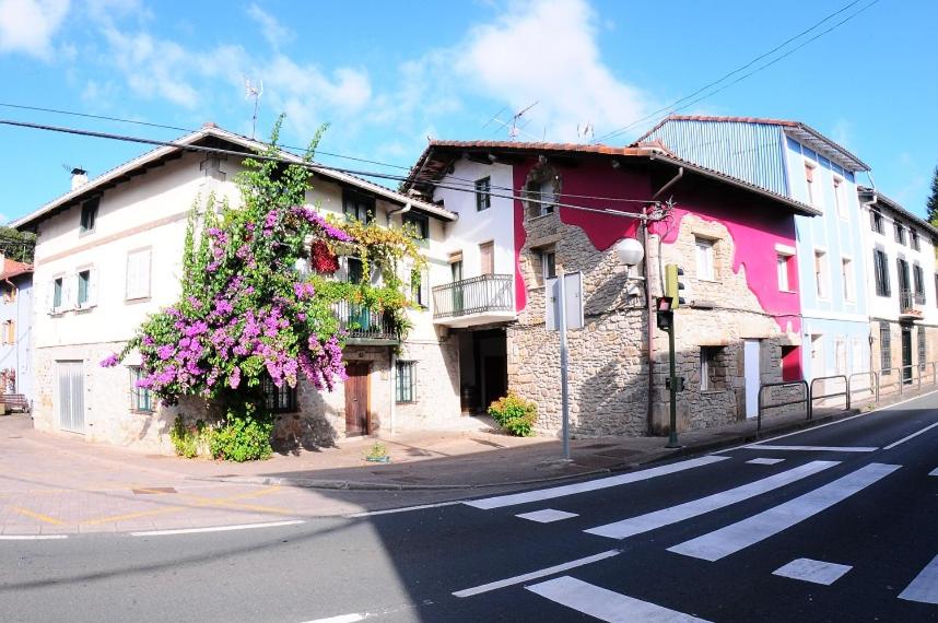 a street with buildings with flowers growing on them at APARTAMENTOs URDAIBAI in Busturia