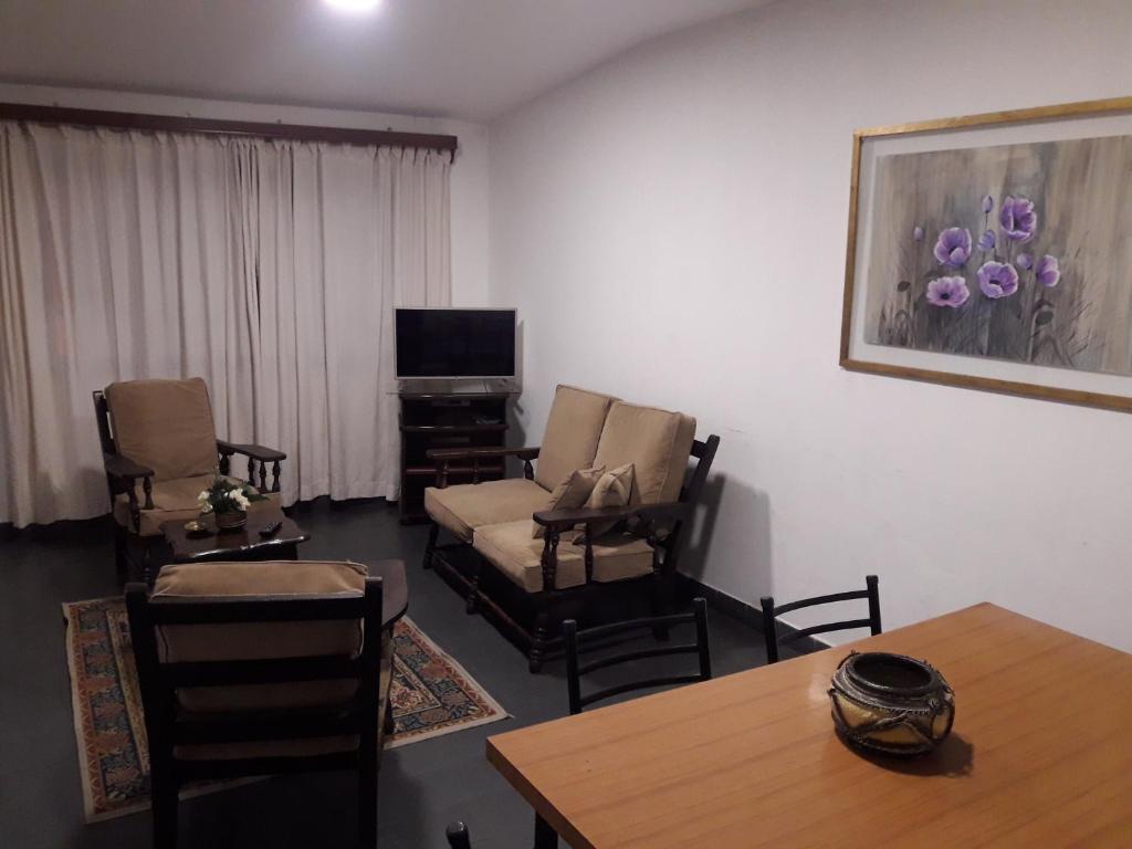 sala de estar con sillas, mesa y TV en Dpto San Martin en Salta