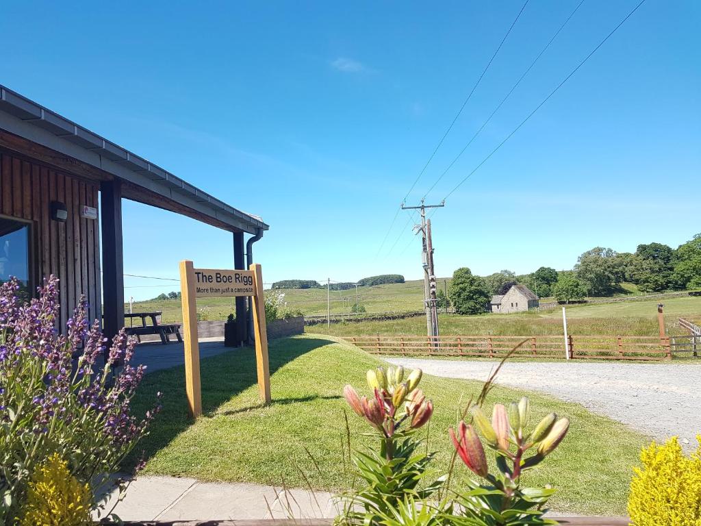 una señal frente a un edificio con flores en The Boe Rigg en Hexham