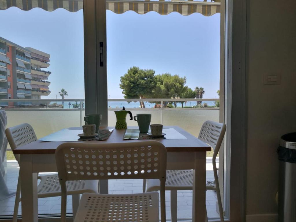 stół i krzesła z widokiem na ocean w obiekcie Mare 3 w mieście Ventimiglia