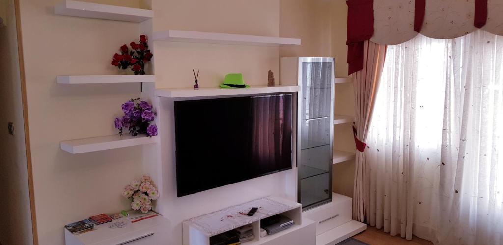 a flat screen tv on a wall with shelves at Casa Jon Con Garage Y Wifi in Barakaldo