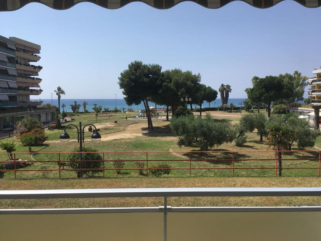 widok na park z drzewami i ocean w obiekcie Mare 3 w mieście Ventimiglia