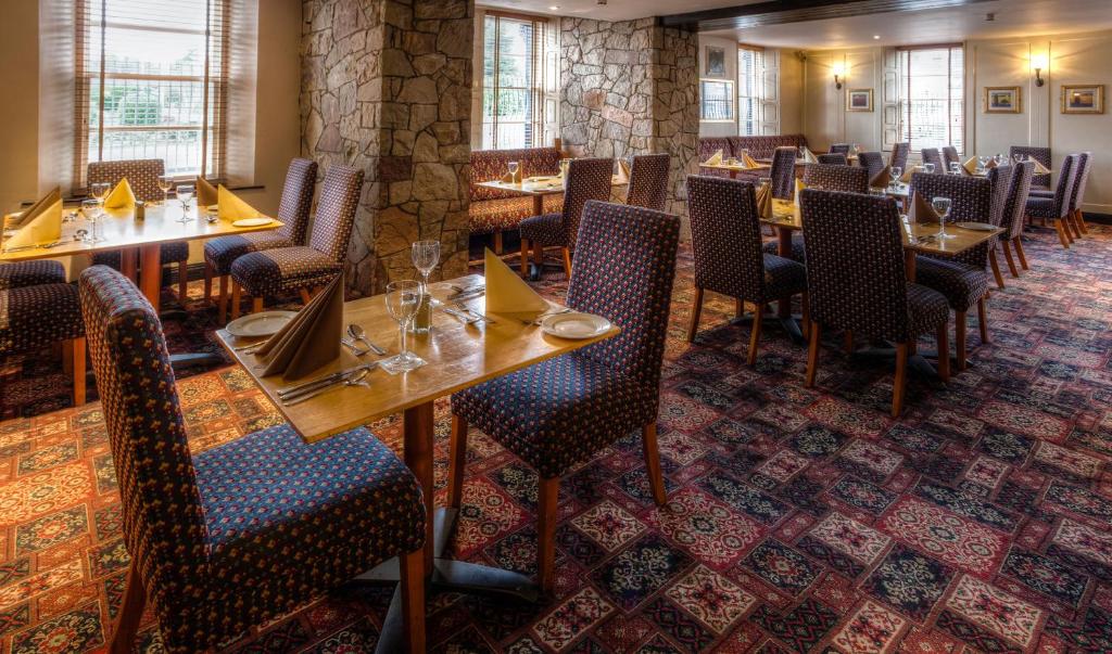 a dining room with wooden tables and chairs at Strangford Arms Hotel in Newtownards