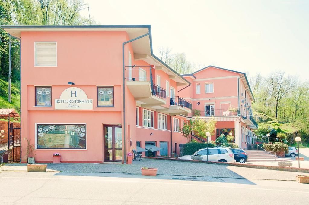 un edificio rosa con un'auto parcheggiata di fronte di Hotel Nella a La Spezia