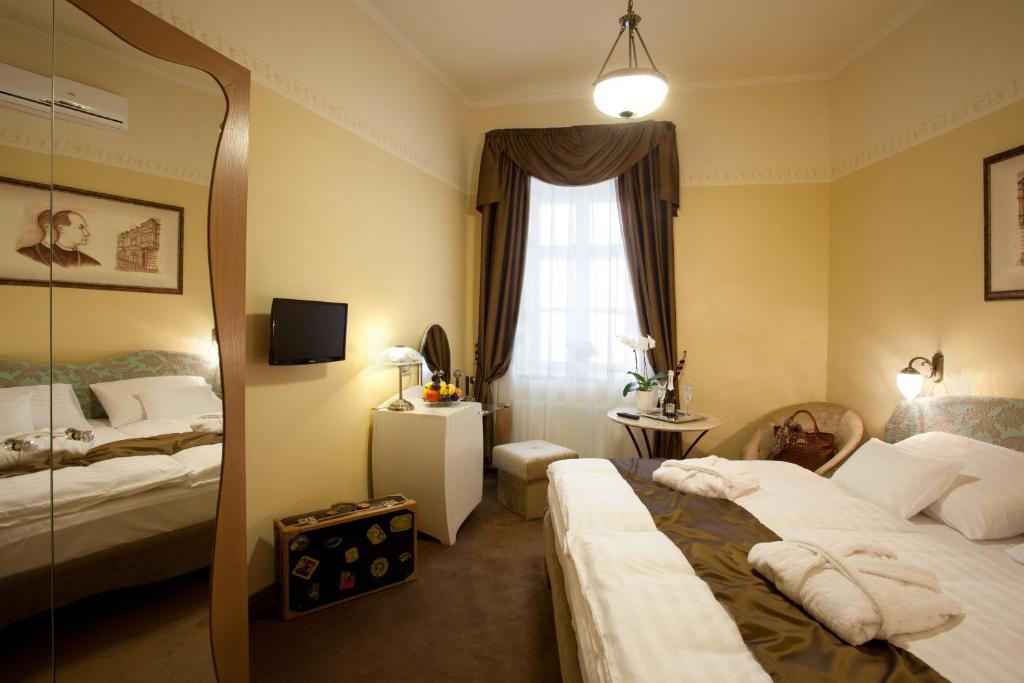 Postel nebo postele na pokoji v ubytování Barokk Hotel Promenád