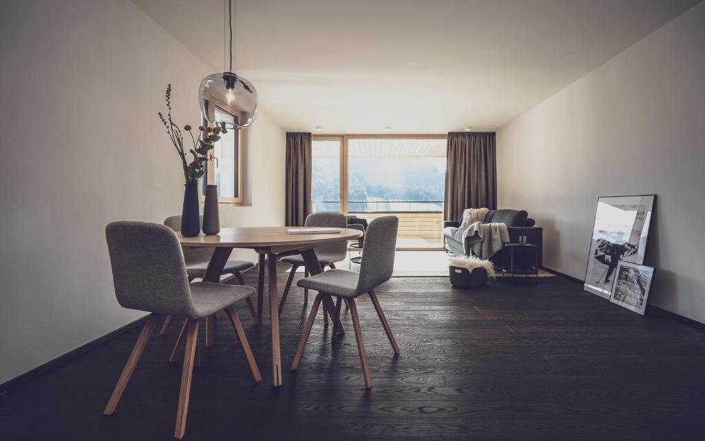 uma sala de jantar com uma mesa de madeira e cadeiras em Parsenn Resort em Davos