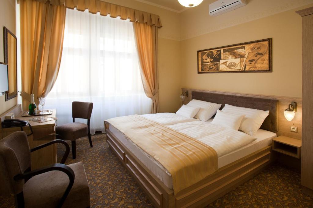 Postel nebo postele na pokoji v ubytování Barokk Hotel Promenád
