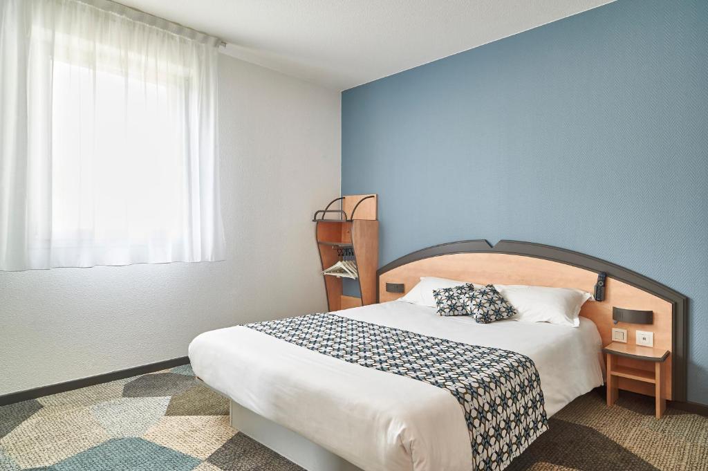 1 dormitorio con 1 cama grande y pared azul en Atena Bordeaux Sud Est Créon - Vélo Friendly, en Créon