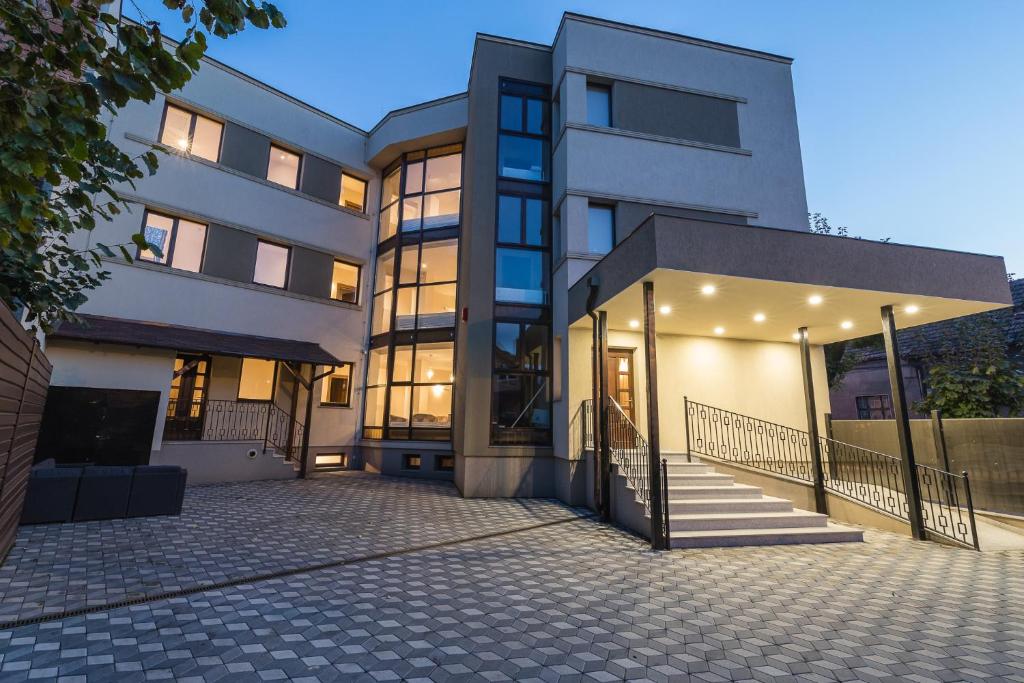un grand bâtiment avec un escalier en face de celui-ci dans l'établissement Pensiunea Select Central, à Târgu-Mureş