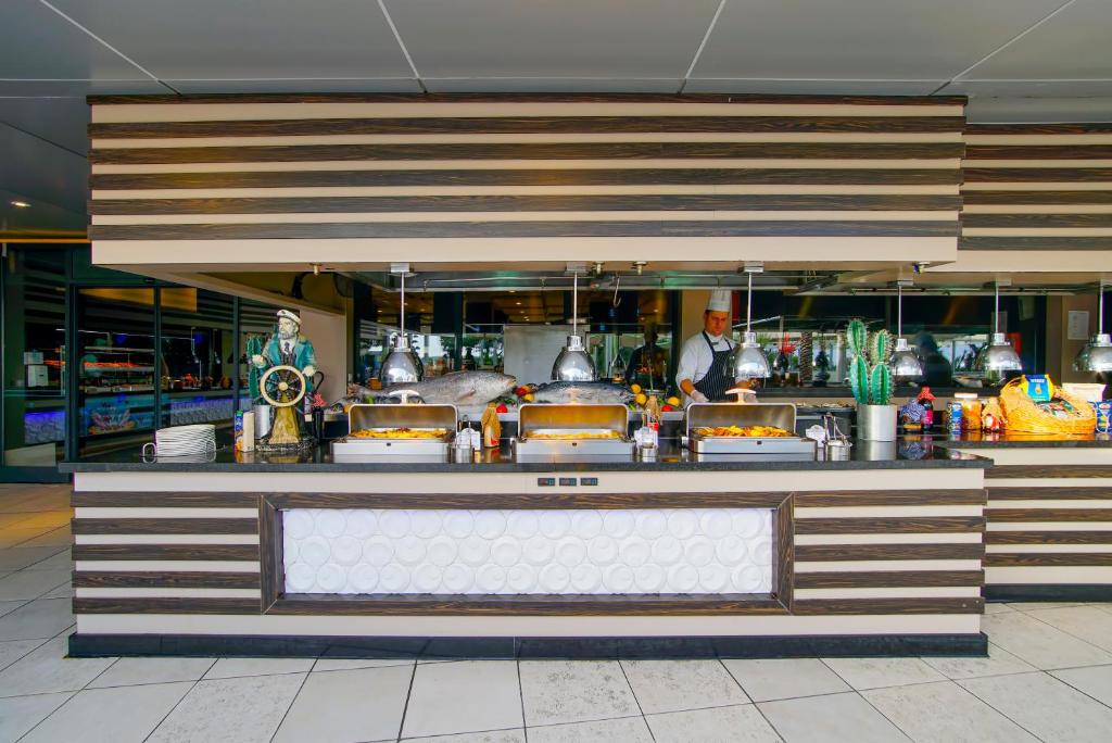 a bar in a restaurant with a chef behind the counter at Limak Atlantis Deluxe Hotel Belek in Belek