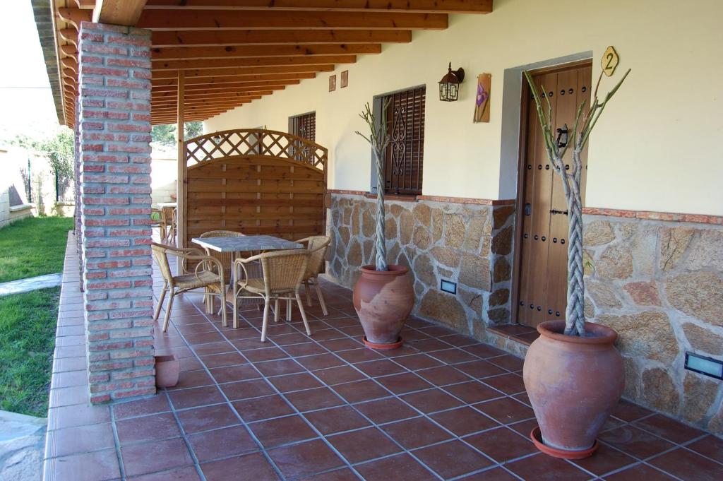 a patio with two large vases and a table at Residencial La Teja in Zahora