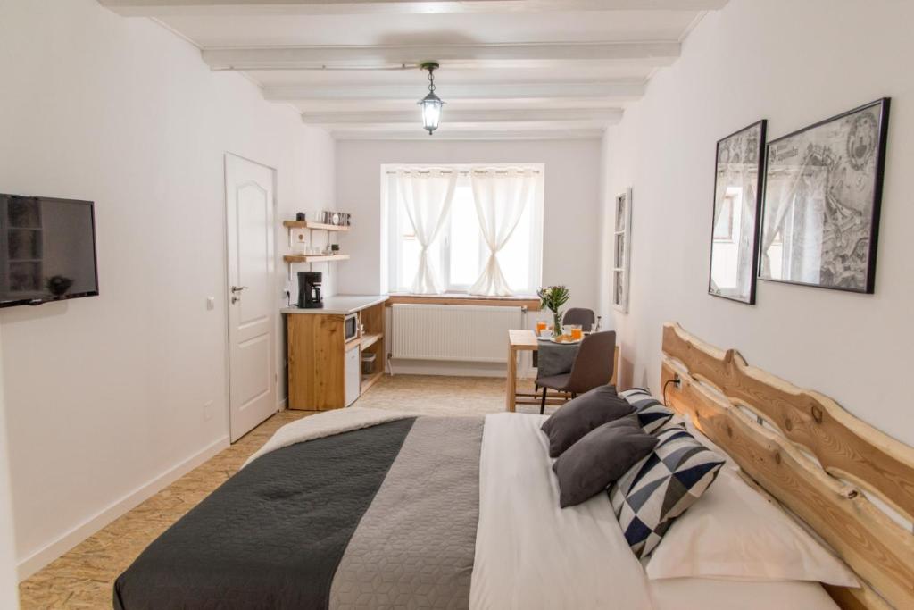 - une chambre avec un grand lit et un bureau dans l'établissement MiddleHouse, à Braşov