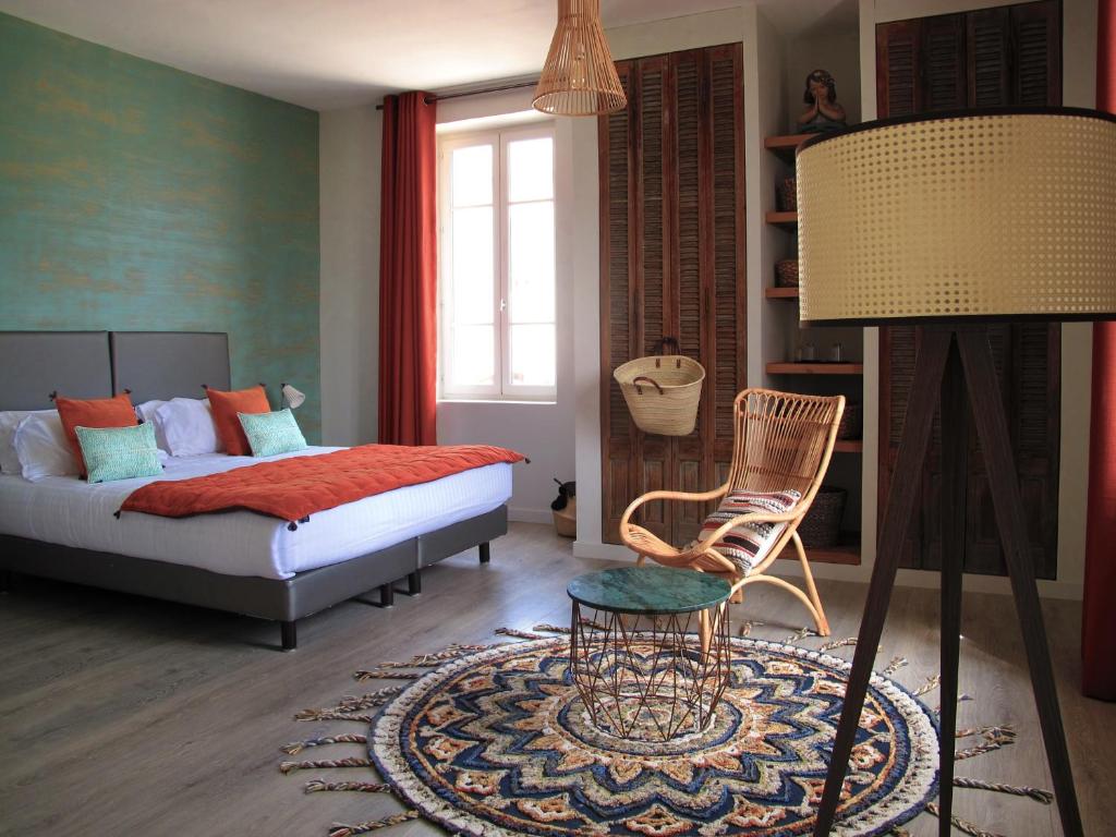 Lagnesにあるla Cour des Sens - La Maisonのベッドルーム1室(ベッド1台、椅子、テーブル付)