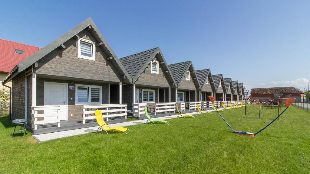 a row of houses with chairs and swings in the yard at Domeczki Blaneczki in Wicie