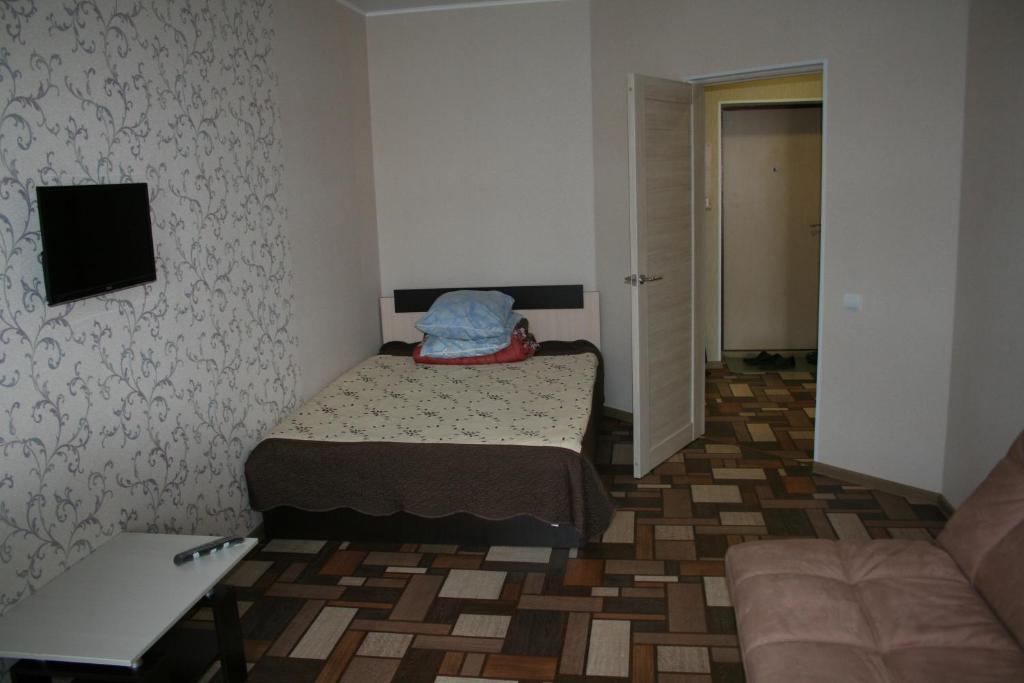 オクチャブリスキーにあるApartment Gubkina 15のベッド2台とソファが備わる小さな客室です。