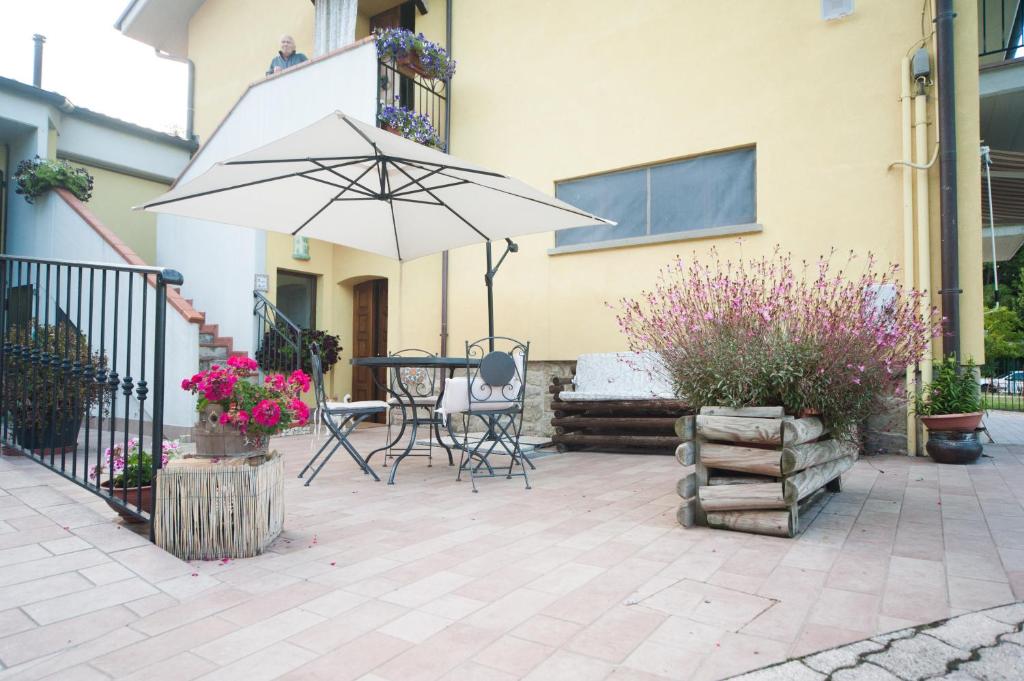 a patio with a table and an umbrella at Il Castagno in Montemonaco