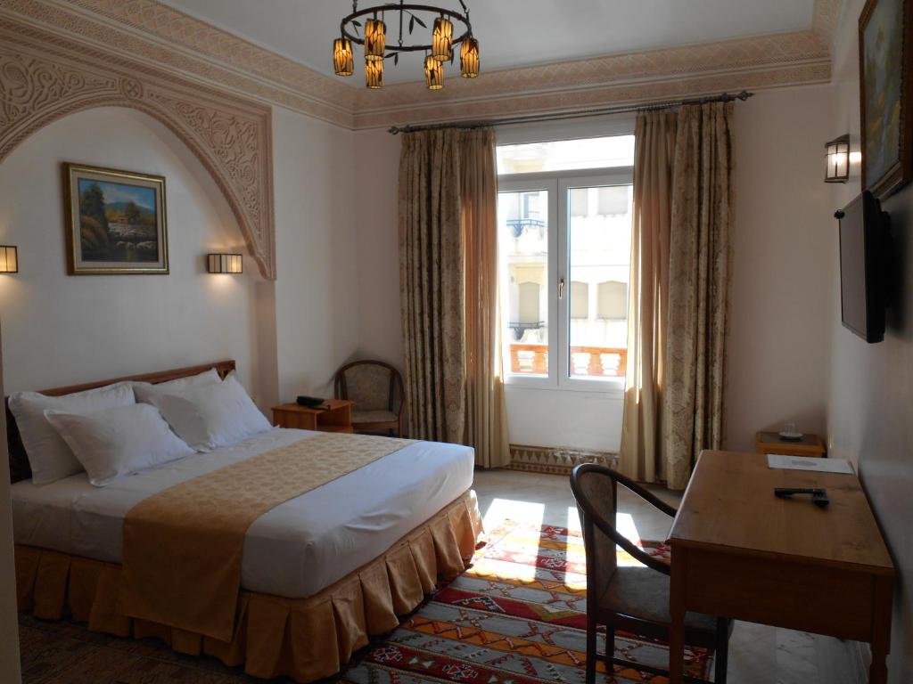 una camera d'albergo con un letto, una scrivania e una finestra di Dar Nador a Nador