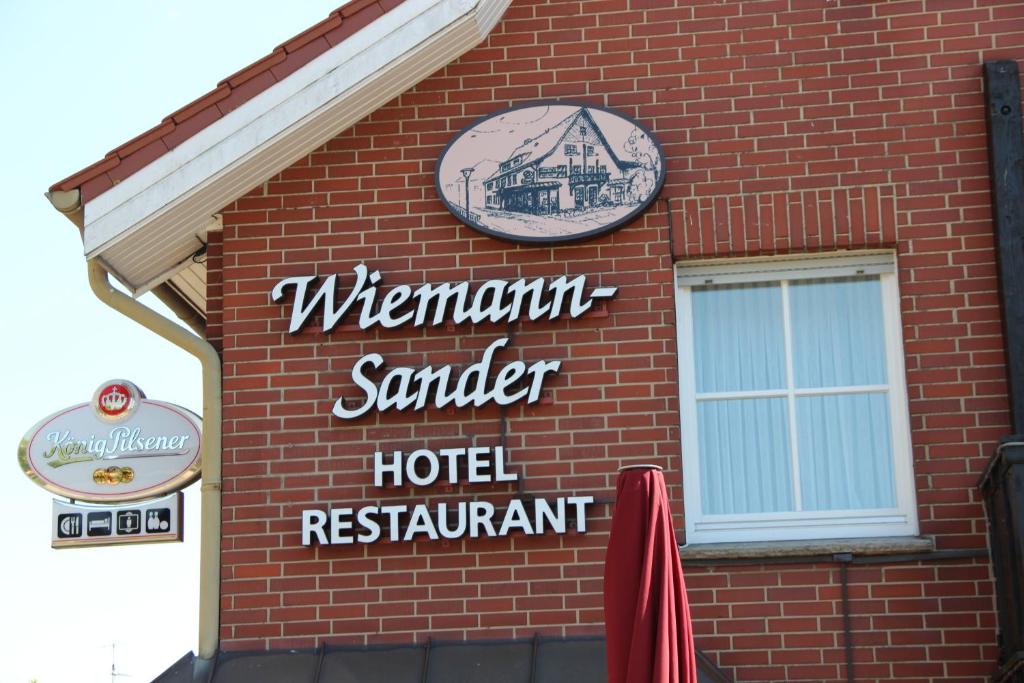 ein Schild für ein Hotel an der Seite eines Backsteingebäudes in der Unterkunft Gasthaus Wiemann-Sander in Bad Iburg