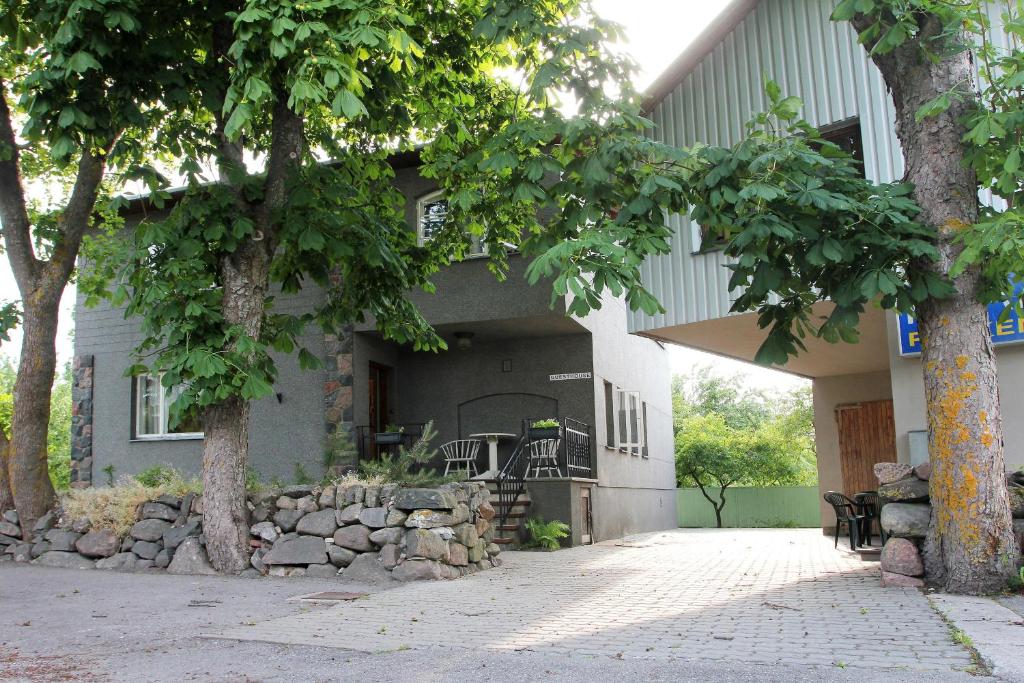 ein Haus mit einer Terrasse und Bäumen davor in der Unterkunft Kraavi Guest Hostel in Kuressaare