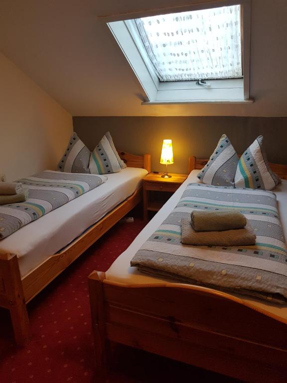 dwa łóżka w pokoju z oknem w obiekcie Pension Streng-Reinhardt w mieście Ostfildern