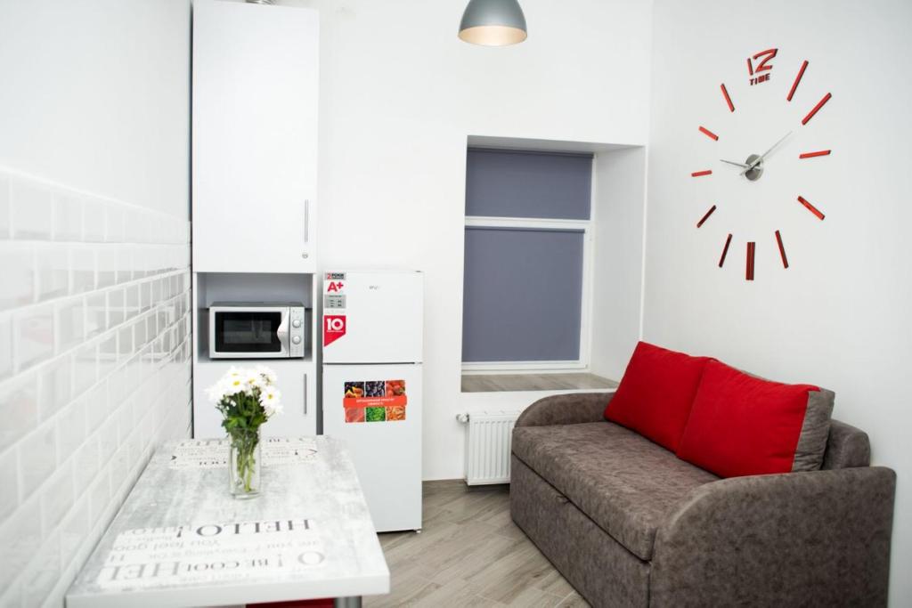 a living room with a couch and a clock on the wall at Deluxe Apartment in old city center in Lviv
