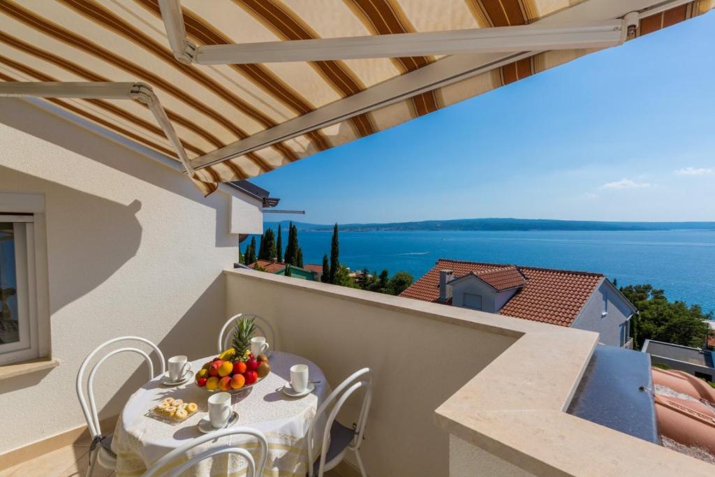 a table and chairs on a balcony with a view of the ocean at Two-Bedroom Apartment in Crikvenica XXXIV in Dramalj