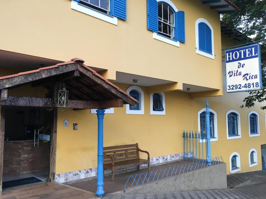 a hotel with a bench in front of a building at Hotel Vila Rica in Alfenas