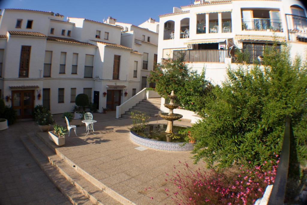 un grupo de edificios blancos con una fuente en un patio en Casa De Los Mandalas, en Altea