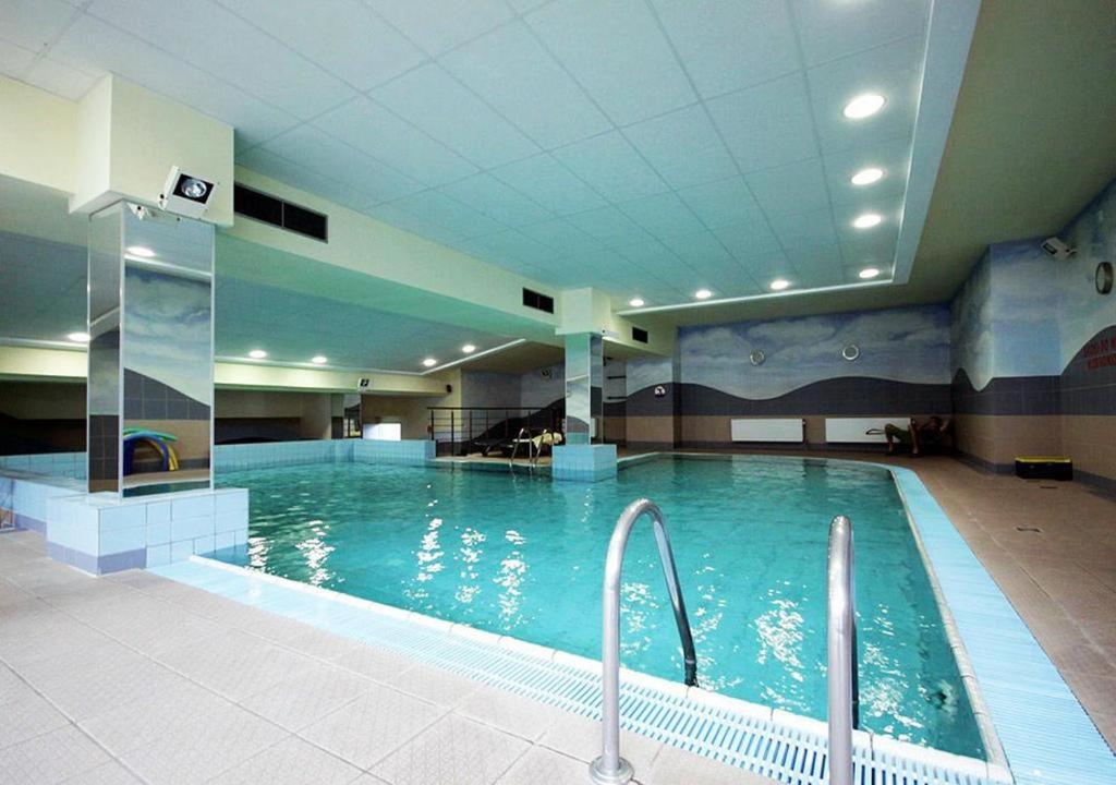 - une grande piscine d'eau bleue dans un bâtiment dans l'établissement Top Loft Warsaw with swimming pool, à Varsovie