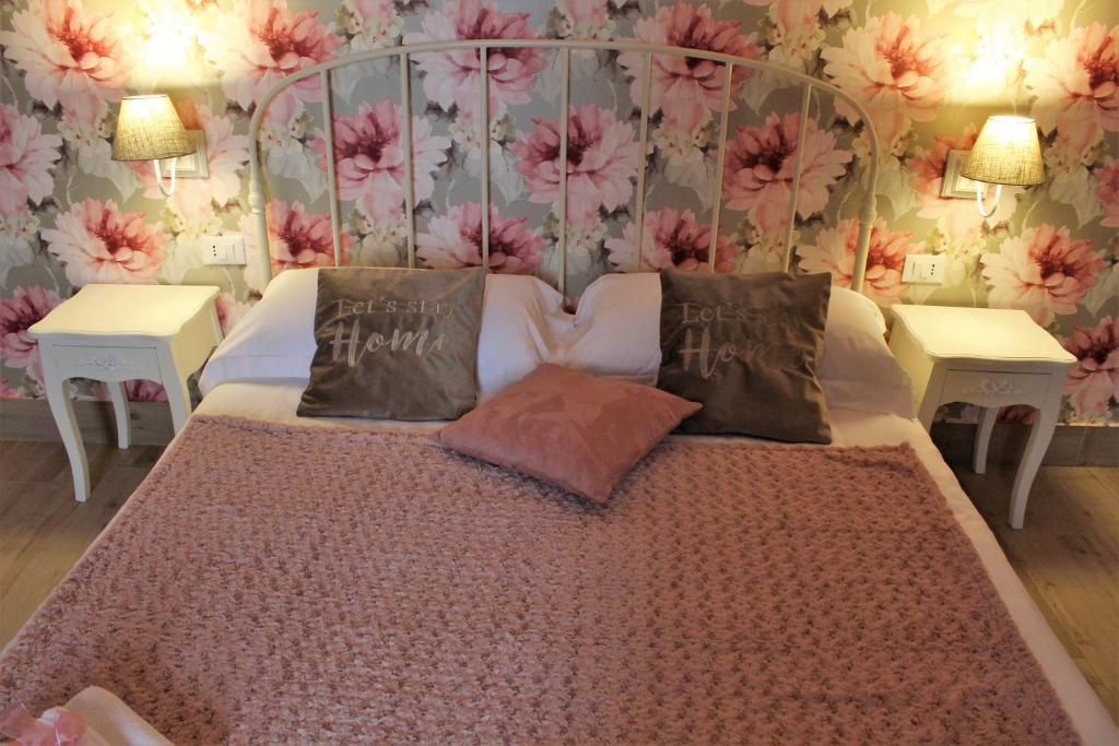 una camera da letto con un grande letto con fiori sul muro di MAISON MARIANNA B&B - ETNA - a Nicolosi