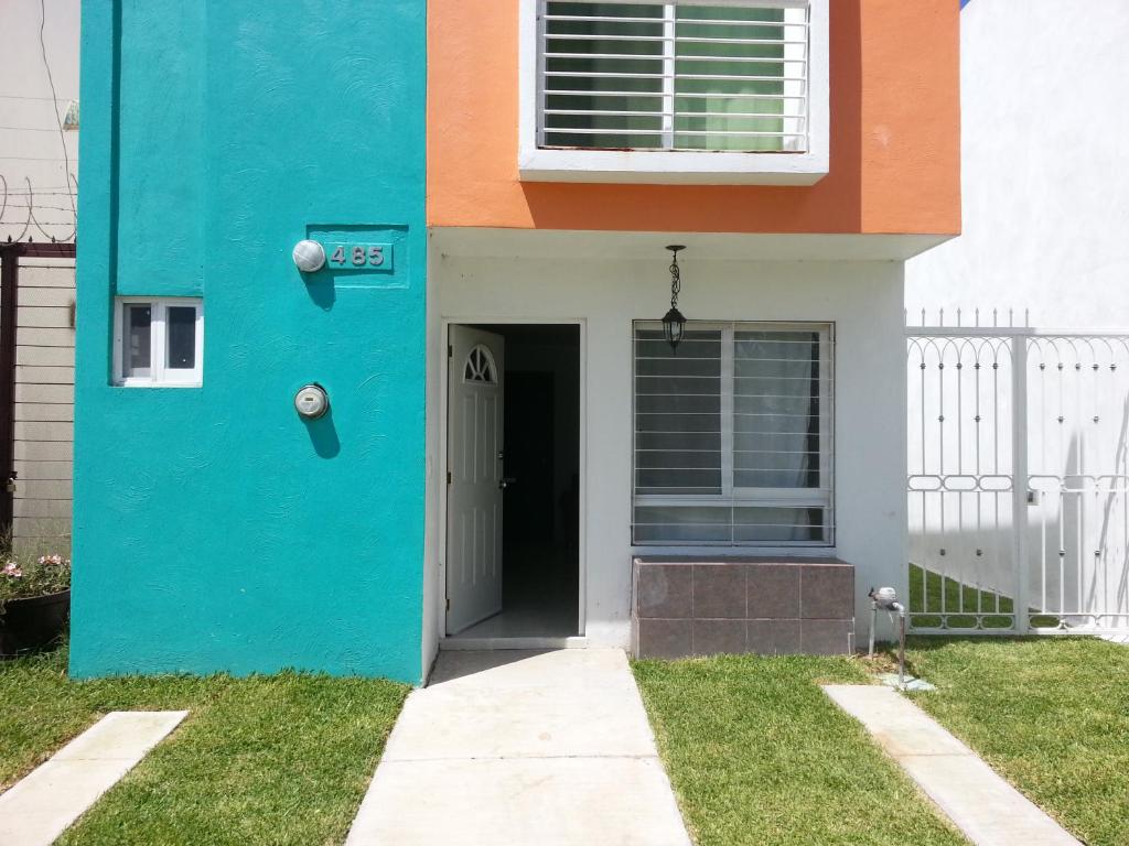 una casa pintada de azul y naranja en Campo Real Oriente, en Guadalajara