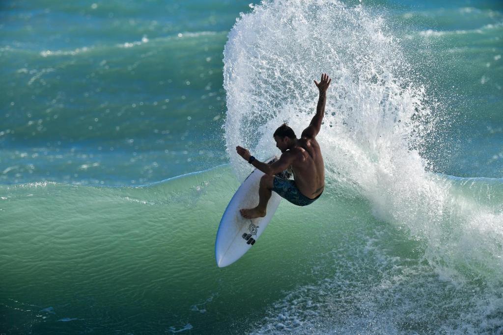 a man riding a wave on a surfboard in the ocean at Wishingwell B&amp;B in Donghe