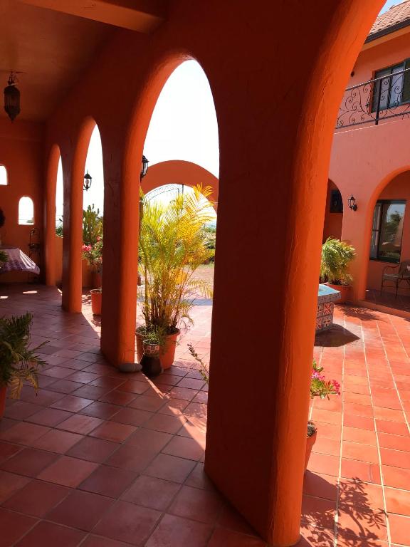 an empty courtyard with orange arches and potted plants at Wishingwell B&amp;B in Donghe