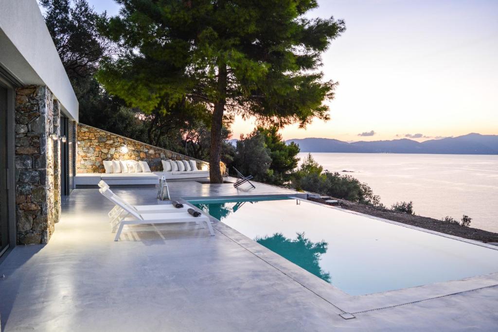 a swimming pool with a view of the water at Thalasses Villas Skiathos in Skiathos Town