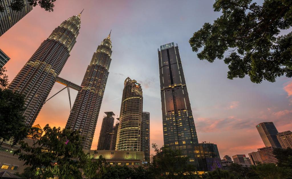 a group of four tall buildings in a city at Four Seasons Hotel Kuala Lumpur in Kuala Lumpur